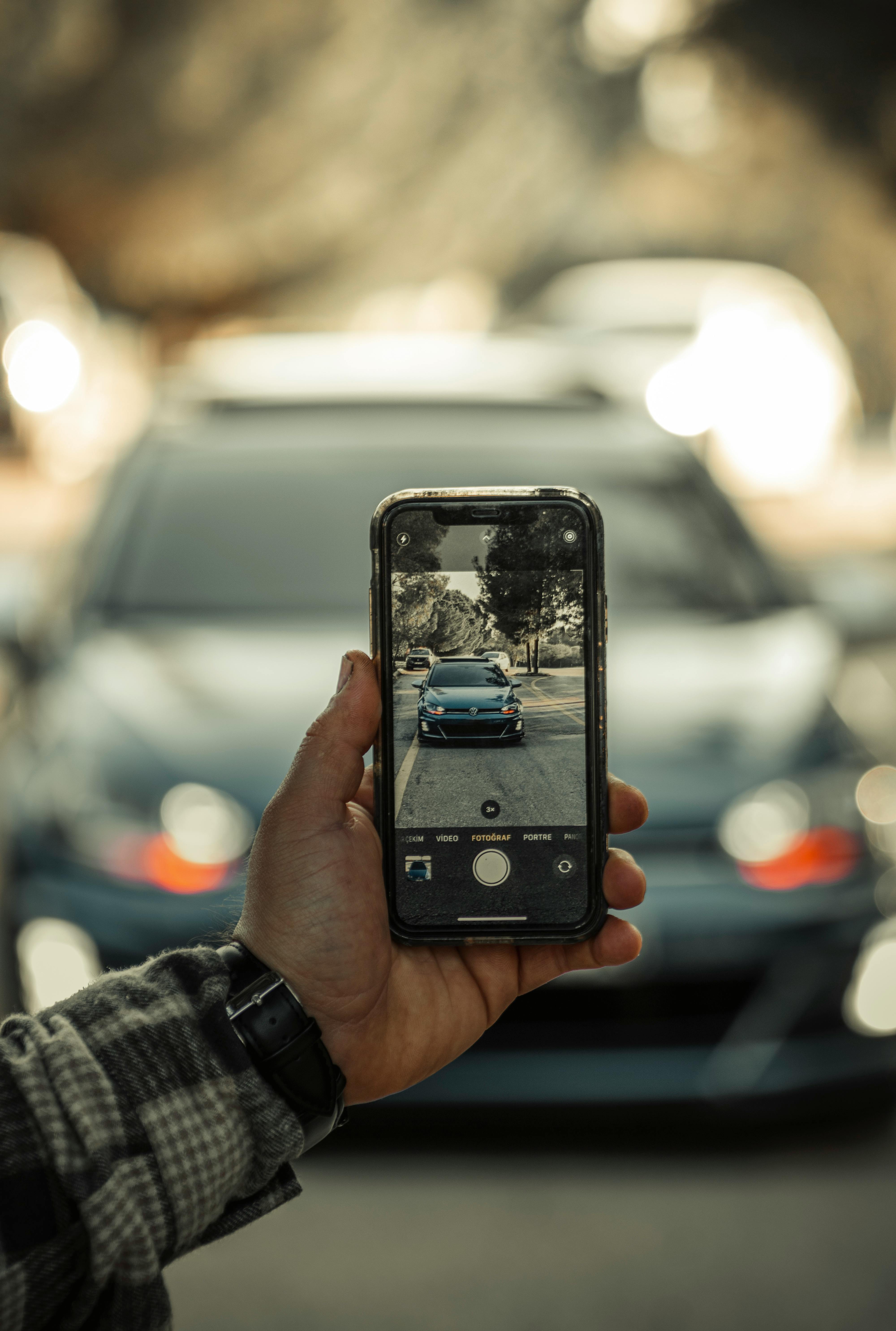 Fahrer dokumentiert ein Fahrzeug mit der BeamMyCar-App auf dem Smartphone